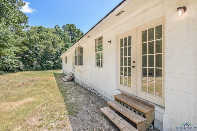 view of side of home with a yard and french doors