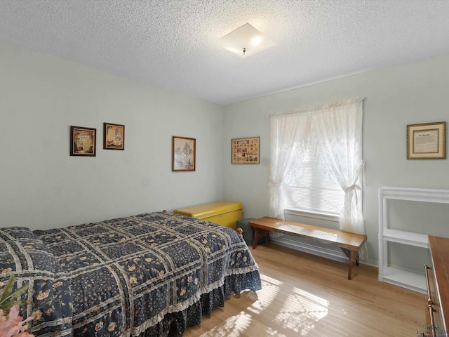 bedroom featuring wood finished floors and a textured ceiling