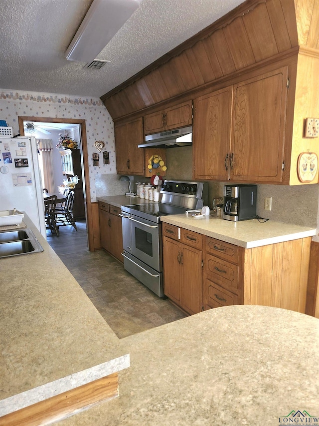 kitchen featuring visible vents, freestanding refrigerator, light countertops, electric stove, and under cabinet range hood