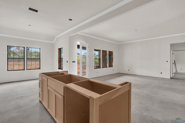 kitchen featuring light brown cabinetry, a center island, crown molding, and a healthy amount of sunlight