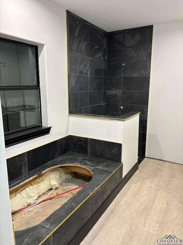 bathroom featuring a tub to relax in and wood-type flooring