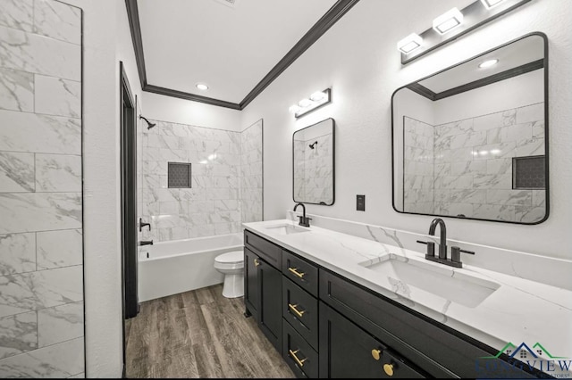 full bathroom with tiled shower / bath combo, crown molding, hardwood / wood-style floors, toilet, and vanity