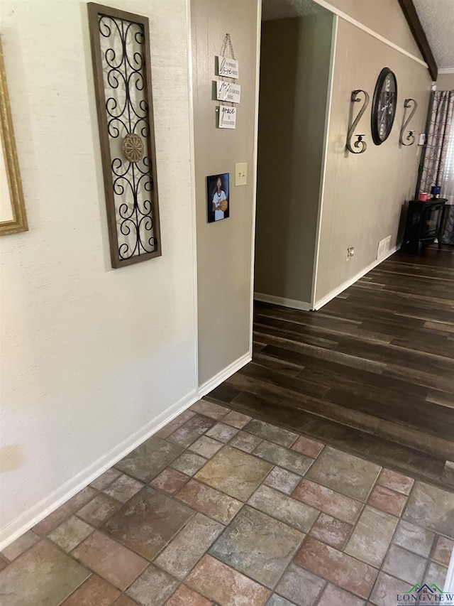 509 Pinewood Dr, Marshall, TX 75672 - corridor featuring baseboards, vaulted ceiling, and brick patterned floors