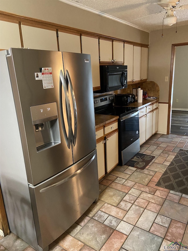 509 Pinewood Dr, Marshall, TX 75672 - kitchen featuring stainless steel appliances, cream cabinets, a ceiling fan, stone tile floors, and a textured ceiling