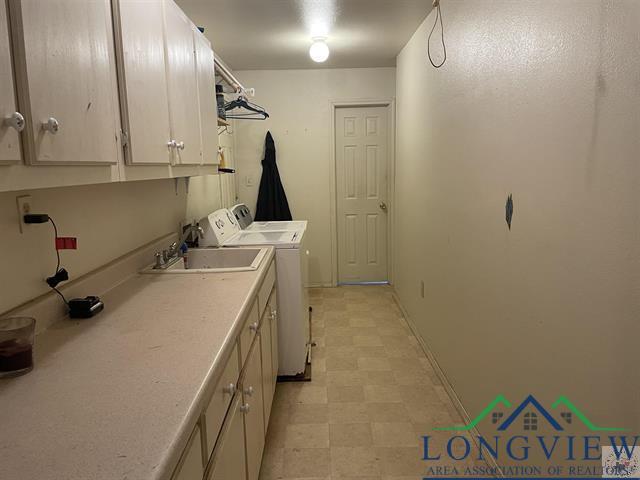 laundry area with cabinets, sink, and washer and dryer