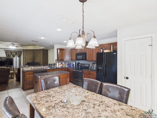kitchen with ceiling fan with notable chandelier, black appliances, a center island, a sink, and open floor plan