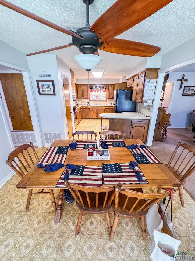 1226 County Road 1896, Linden, TX 75563 - dining area featuring a ceiling fan, a textured ceiling, and light colored carpet