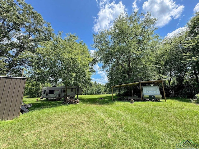 1226 County Road 1896, Linden, TX 75563 - view of green lawn with a detached carport and an outbuilding