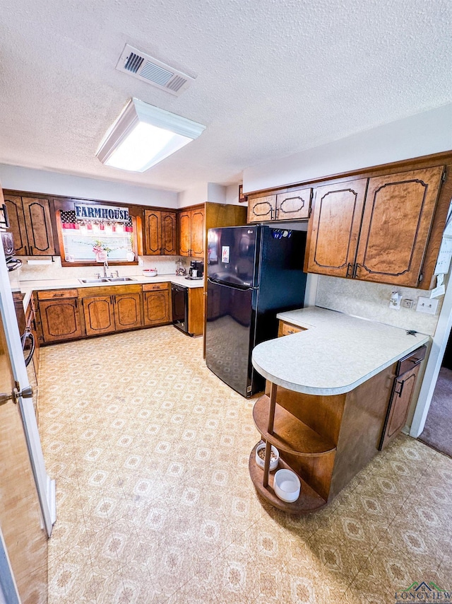 1226 County Road 1896, Linden, TX 75563 - kitchen with black appliances, brown cabinets, a textured ceiling, light countertops, and open shelves