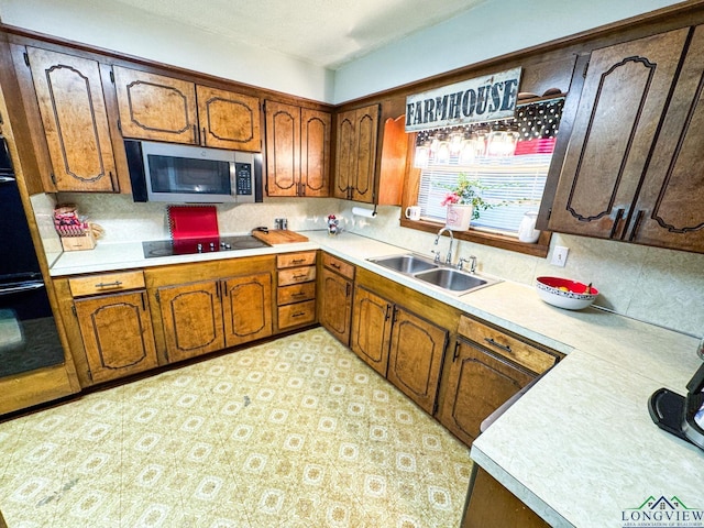 1226 County Road 1896, Linden, TX 75563 - kitchen with stainless steel microwave, black electric stovetop, light countertops, and decorative backsplash