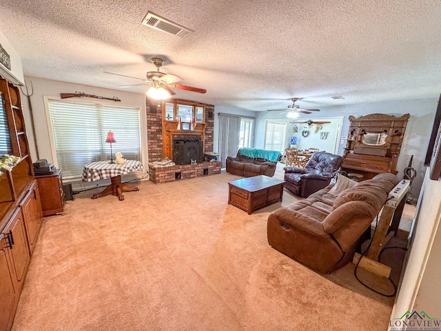 1226 County Road 1896, Linden, TX 75563 - living room featuring a brick fireplace, light colored carpet, ceiling fan, and a textured ceiling