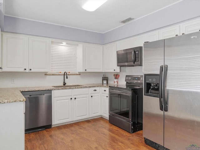 kitchen featuring white cabinetry, sink, hardwood / wood-style floors, and appliances with stainless steel finishes