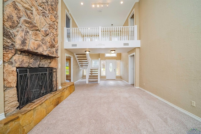 1822 Northwood Ct, Longview, TX 75604 - unfurnished living room featuring carpet, stairway, baseboards, a fireplace, and a high ceiling