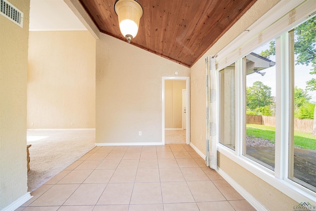1822 Northwood Ct, Longview, TX 75604 - unfurnished room with lofted ceiling, wood ceiling, a textured wall, light tile patterned flooring, and light carpet