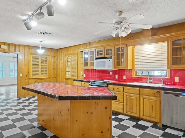 kitchen featuring plenty of natural light, dishwasher, light floors, range, and white microwave