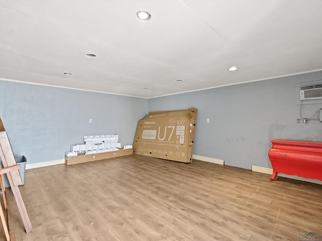 interior space with recessed lighting, wood finished floors, baseboards, and a wall mounted air conditioner