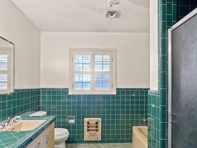 full bathroom with toilet, walk in shower, visible vents, and tile walls