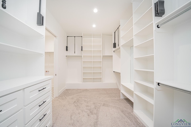 walk in closet featuring light carpet