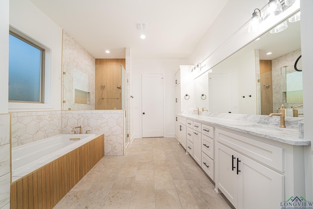 bathroom featuring independent shower and bath, tile walls, and vanity