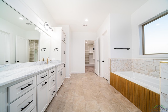 bathroom with a washtub and vanity