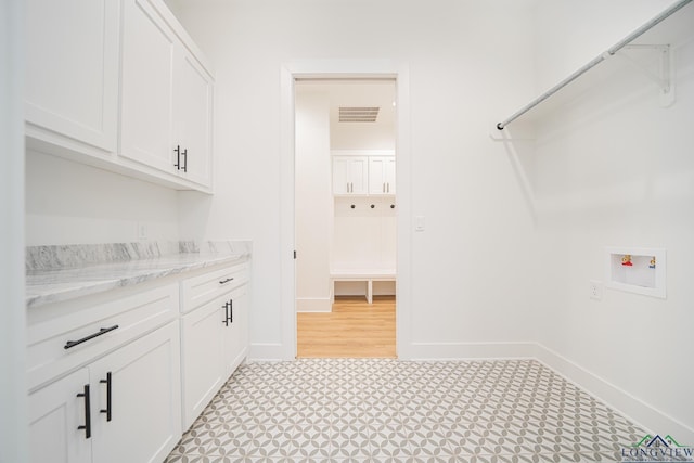 washroom with washer hookup and cabinets