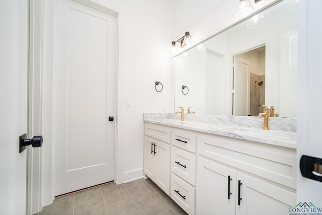 bathroom with walk in shower, vanity, and tile patterned flooring