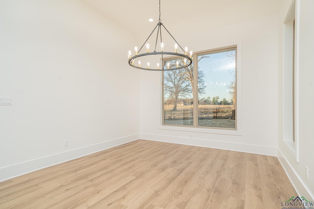 unfurnished dining area featuring a notable chandelier and light hardwood / wood-style floors