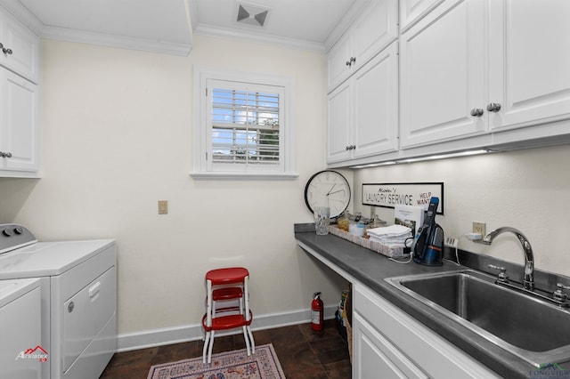 clothes washing area with washing machine and dryer, sink, cabinets, and ornamental molding