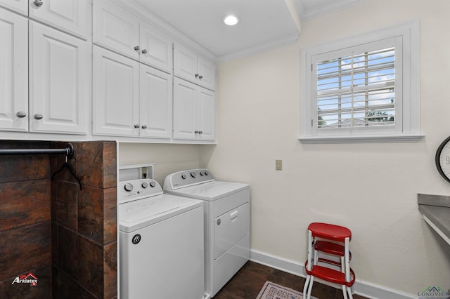 clothes washing area with crown molding, washer and dryer, and cabinets