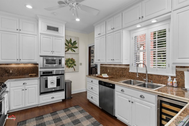 kitchen featuring white cabinets, sink, stainless steel appliances, and beverage cooler