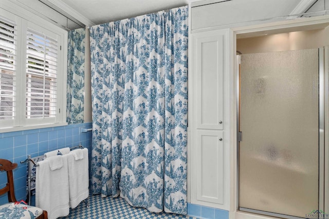 bathroom with an enclosed shower, tile walls, and ornamental molding