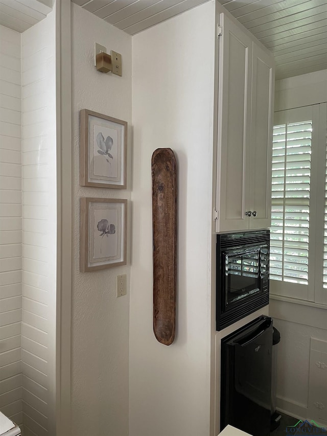 interior details featuring white cabinets, black microwave, and dishwasher