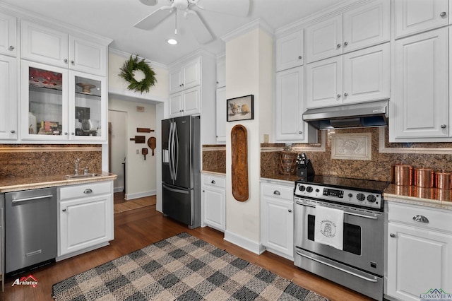 kitchen with backsplash, ornamental molding, stainless steel appliances, dark wood-type flooring, and white cabinetry