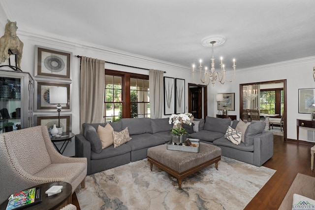 living room with crown molding, hardwood / wood-style floors, and an inviting chandelier