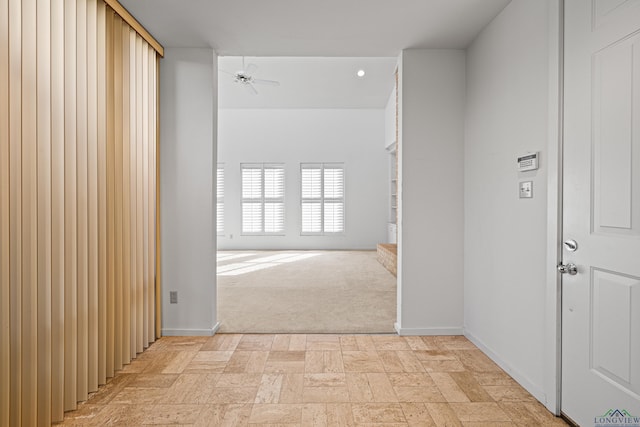 hall with light colored carpet