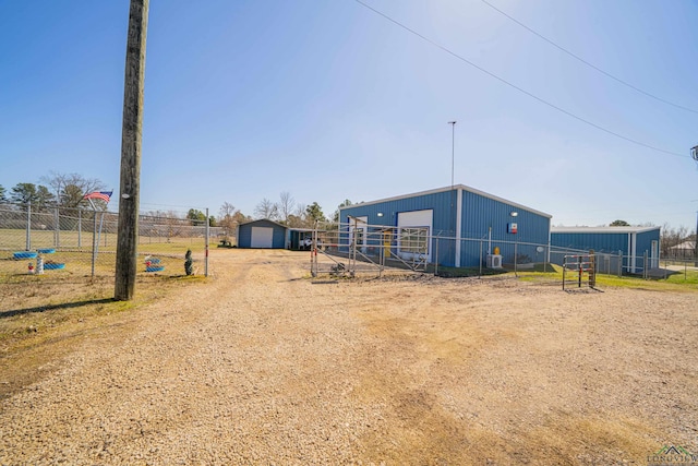 exterior space with a garage, an outbuilding, and fence