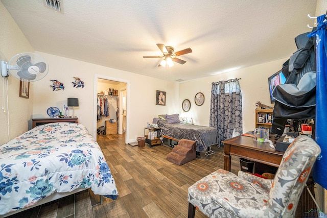 bedroom with a textured ceiling, visible vents, and wood finished floors