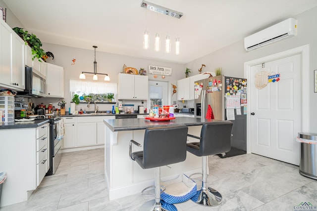 kitchen featuring appliances with stainless steel finishes, a wall mounted AC, dark countertops, and a sink