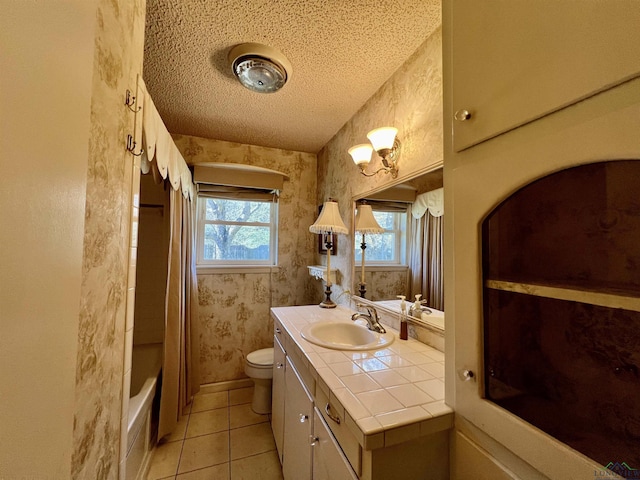 full bathroom with vanity, tile patterned floors, toilet, shower / bathtub combination with curtain, and a textured ceiling