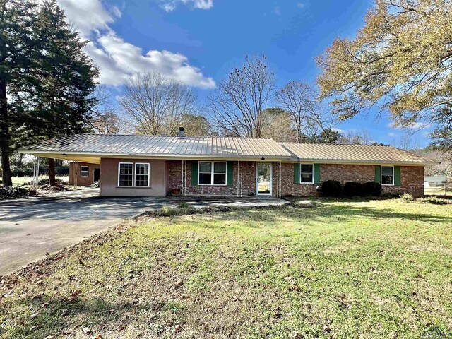 1400 Shreveport St, Elysian Fields, TX 75642 - ranch-style house with a carport, a front yard, a metal roof, and driveway