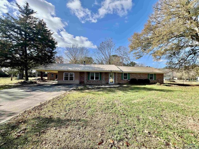 1400 Shreveport St, Elysian Fields, TX 75642 - ranch-style house with a chimney, concrete driveway, a metal roof, and a front yard