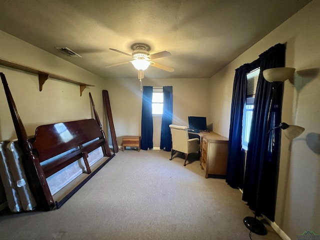 carpeted office space featuring ceiling fan