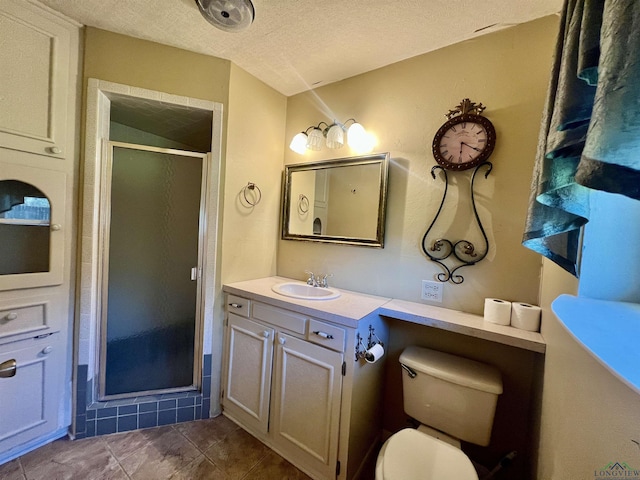 bathroom featuring tile patterned flooring, vanity, a shower with door, and a textured ceiling