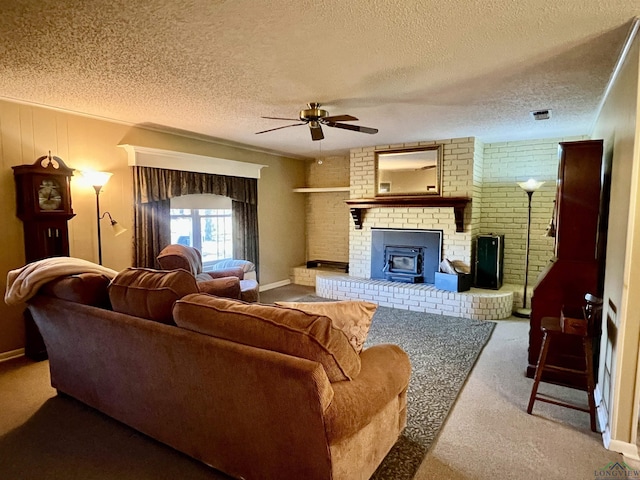 living room with a wood stove, ceiling fan, carpet, and a textured ceiling