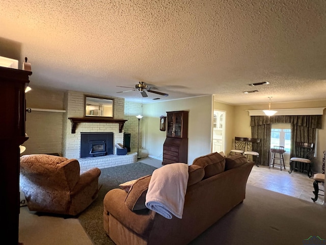 living room featuring a wood stove, ceiling fan, light carpet, and a textured ceiling