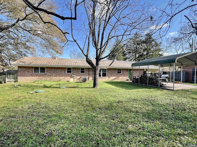 rear view of house featuring a carport and a yard