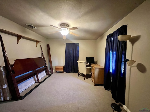 carpeted office space with ceiling fan and a textured ceiling