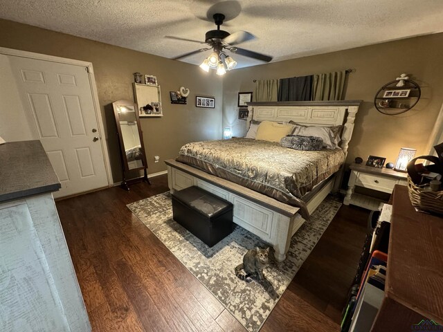 bedroom with ceiling fan, dark hardwood / wood-style flooring, and a textured ceiling