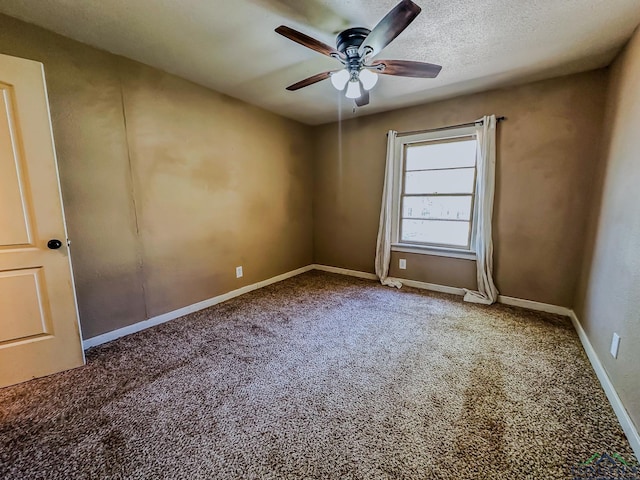 carpeted empty room with baseboards, ceiling fan, and a textured ceiling