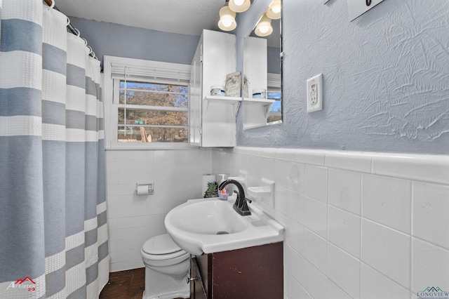 bathroom with vanity, wood-type flooring, tile walls, and toilet